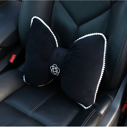 plush black headrest with camellia and butterfly knot design